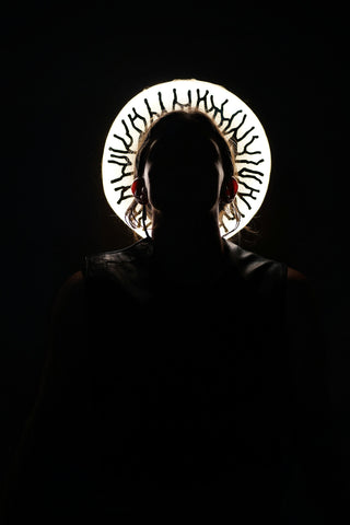 a person standing in a dark room with a circular object on their head